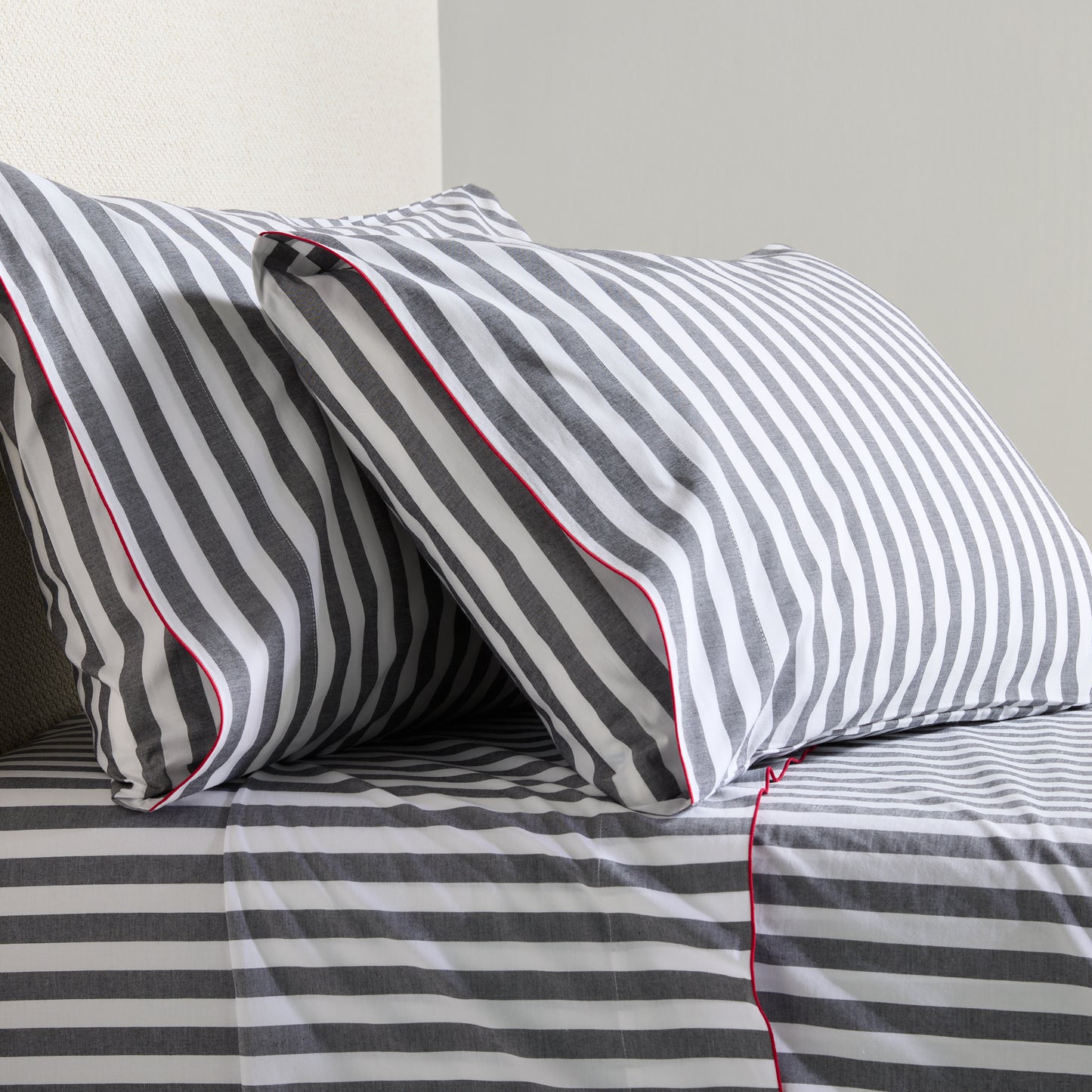 Diane Keaton + Hudson Grace gray and white striped percale sheet set with red trim.