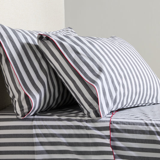 Diane Keaton + Hudson Grace gray and white striped percale sheet set with red trim.