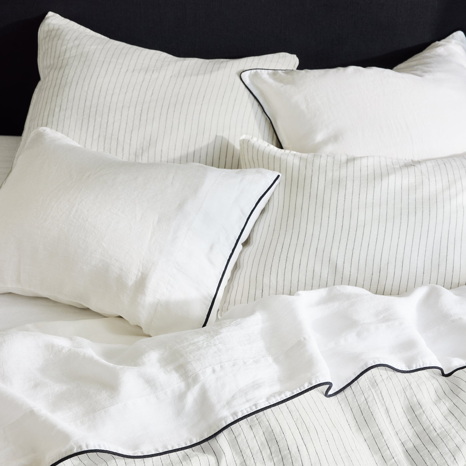 Diane Keaton + Hudson Washed Linen Duvet Cover and shams with black piping, white with subtle stripes.