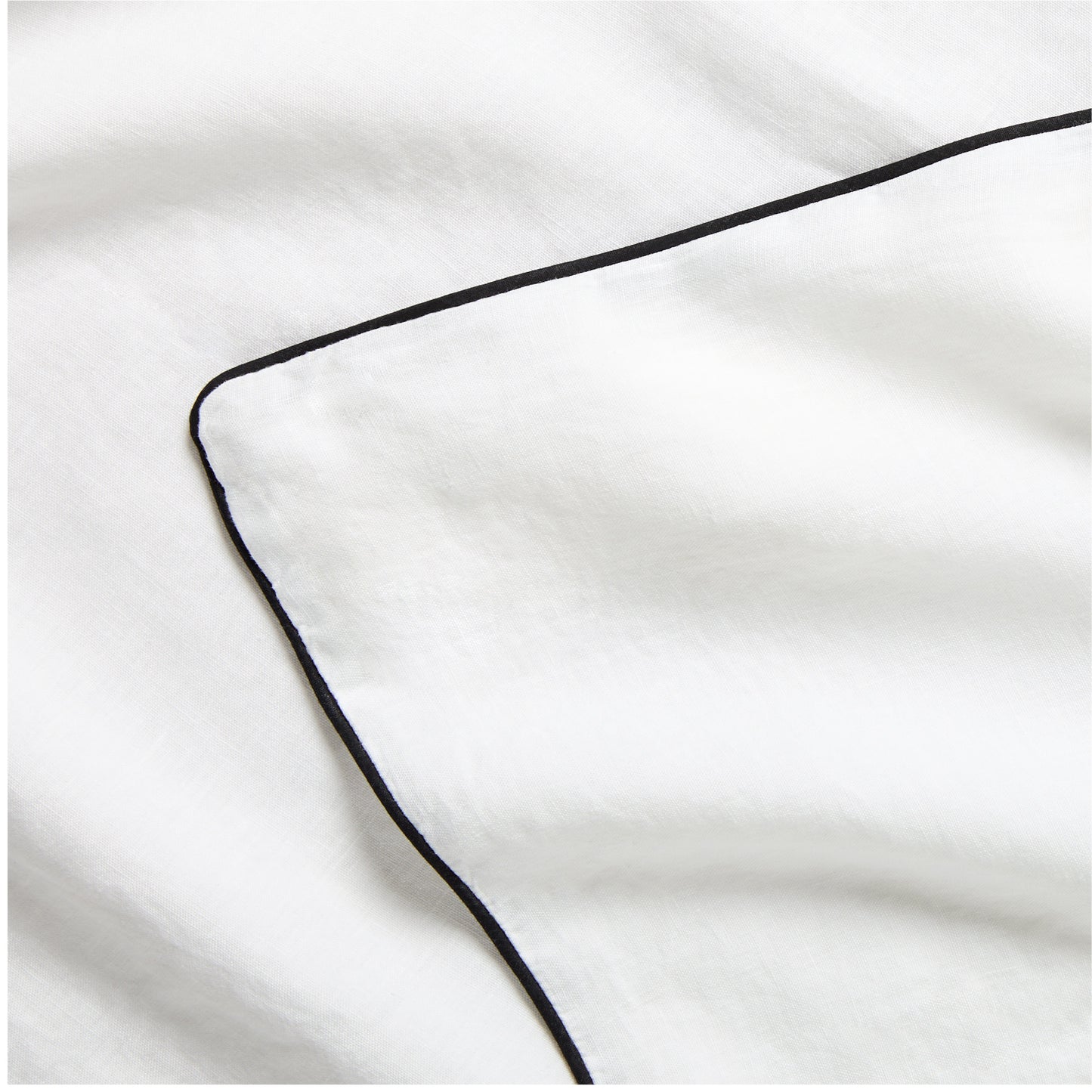 Diane Keaton + Hudson Washed Linen Duvet Cover, white with black piping, close-up.