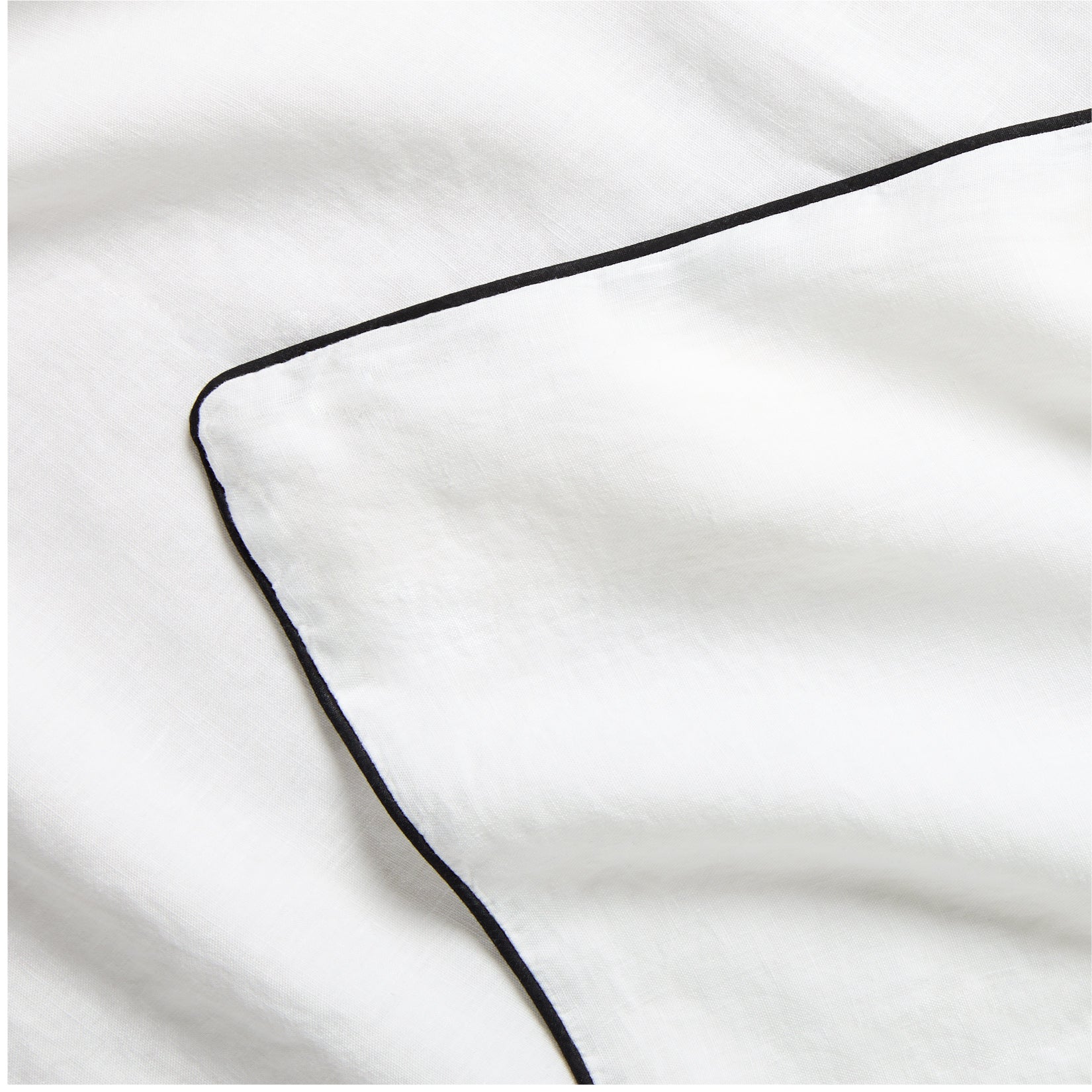 Diane Keaton + Hudson Washed Linen Duvet Cover, white with black piping, close-up.