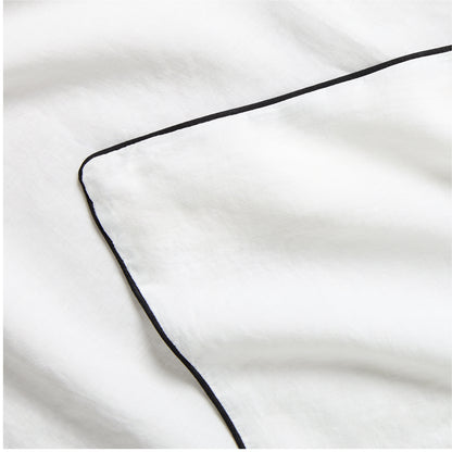 Diane Keaton + Hudson Washed Linen Duvet Cover, white with black piping, close-up.