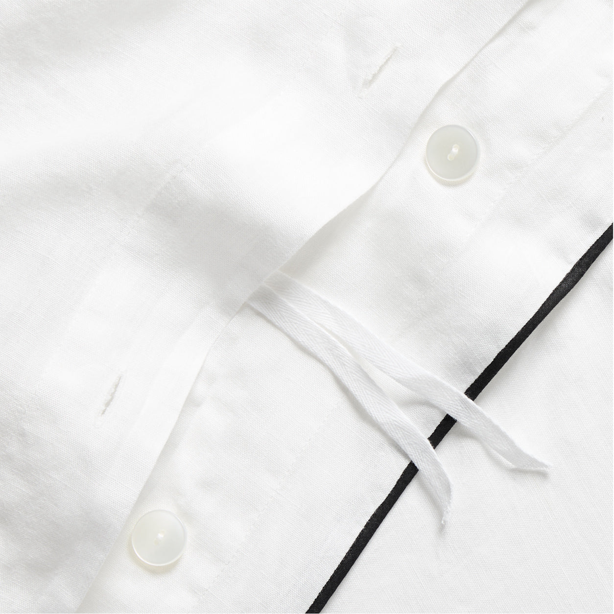 Diane Keaton + Hudson Washed Linen Duvet Cover, white with black piping, button closure, and ties.