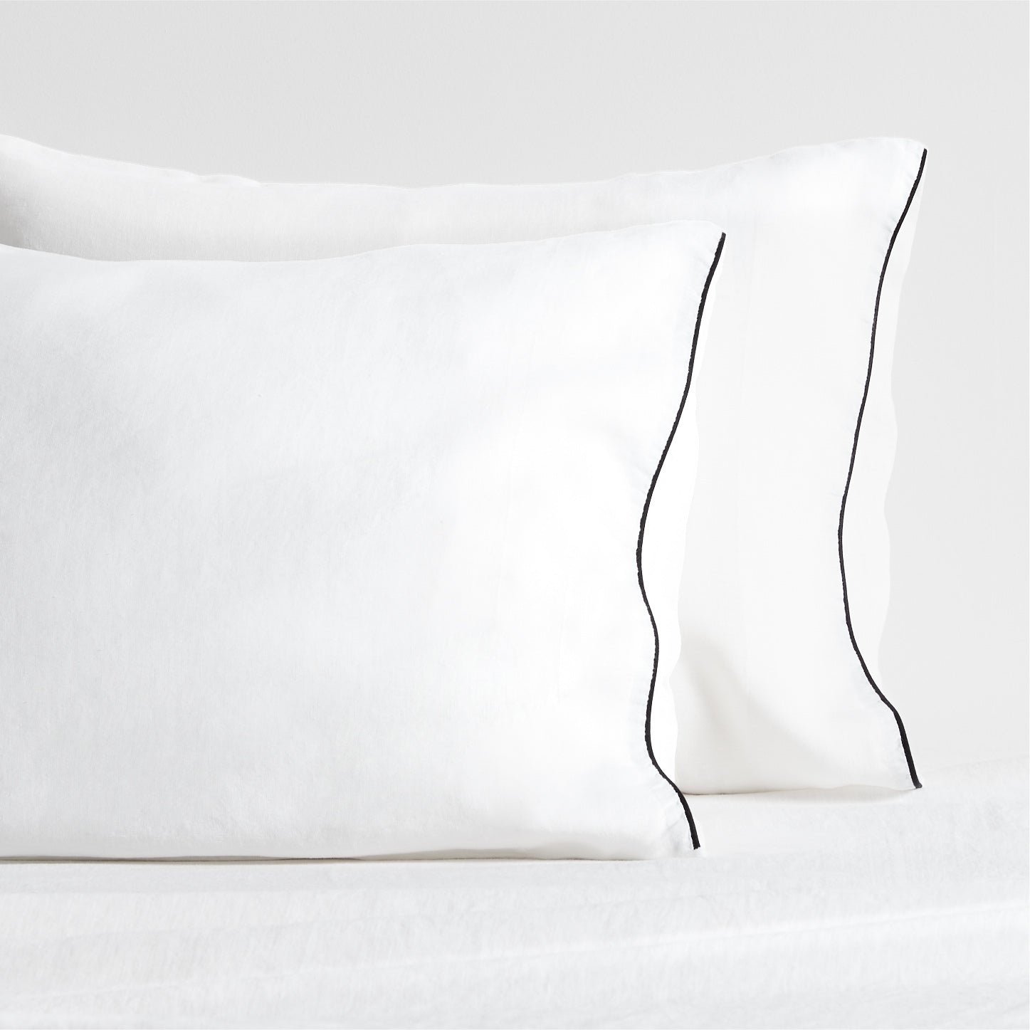 Diane Keaton + Hudson white washed linen pillowcases with black piping.