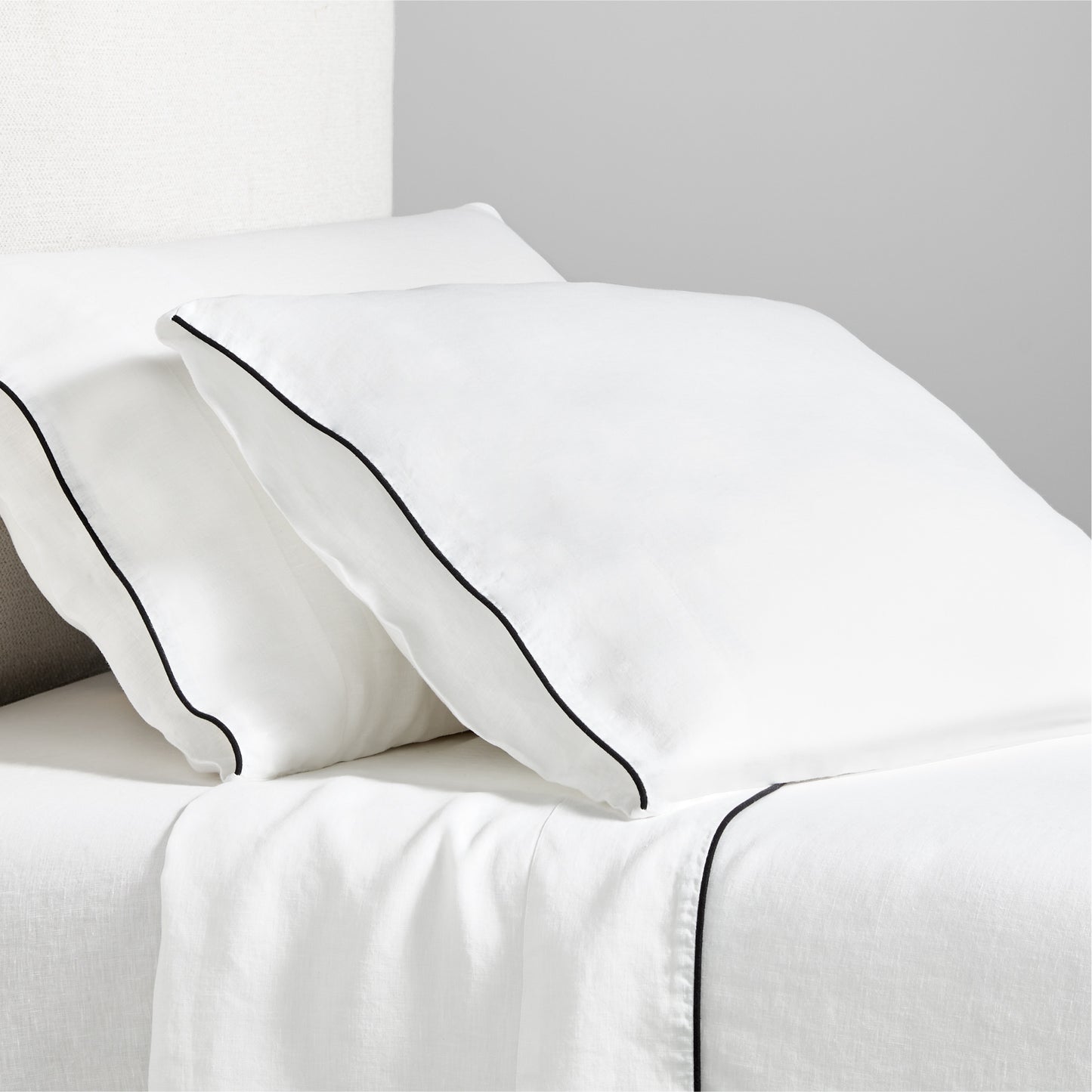 Diane Keaton + Hudson white washed linen sheet set with black piping on pillows and flat sheet.