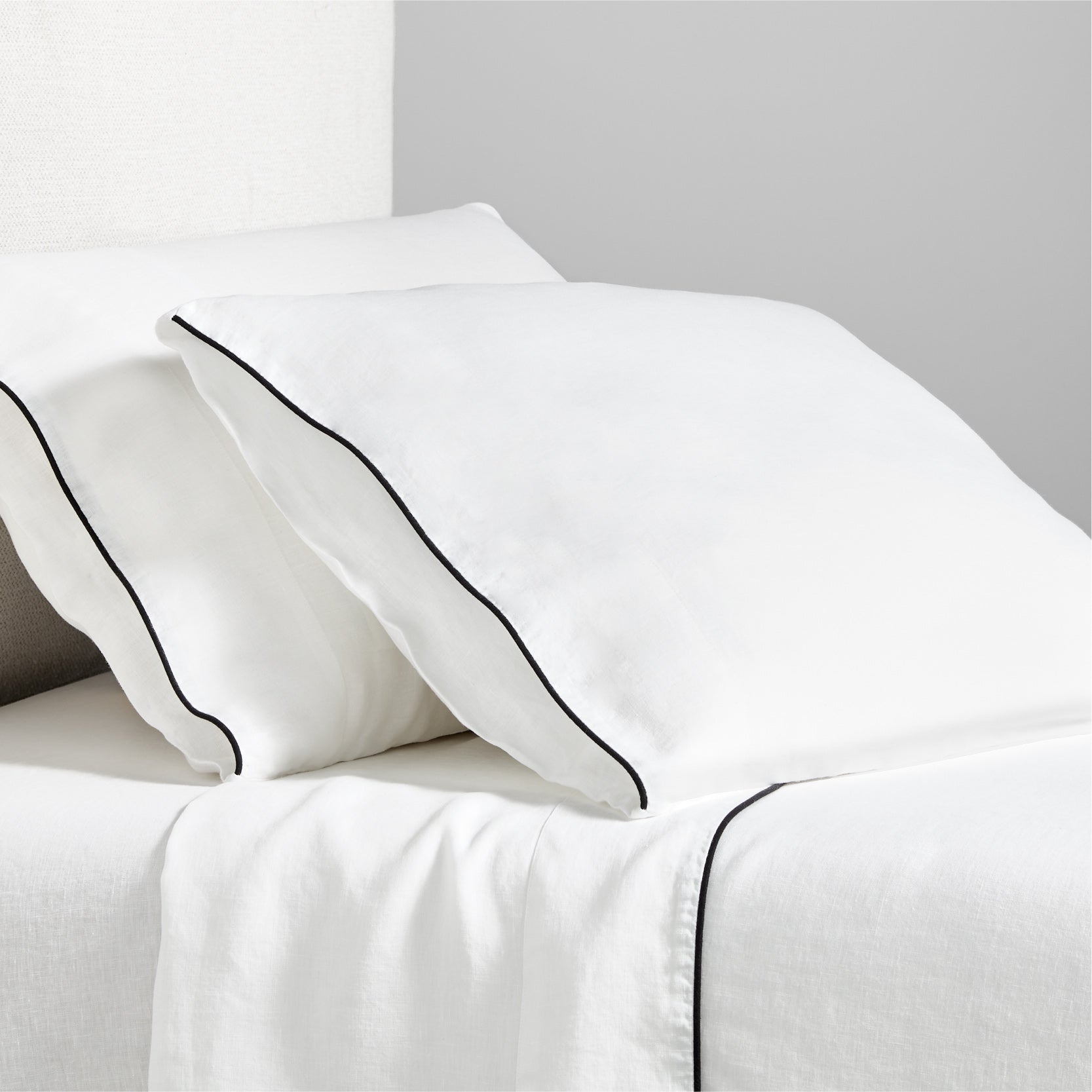Diane Keaton + Hudson white washed linen sheet set with black piping on pillows and flat sheet.