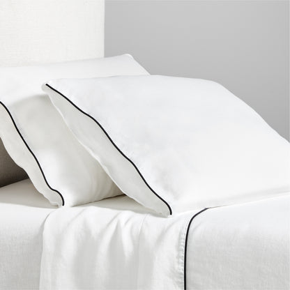Diane Keaton + Hudson white washed linen sheet set with black piping on pillows and flat sheet.