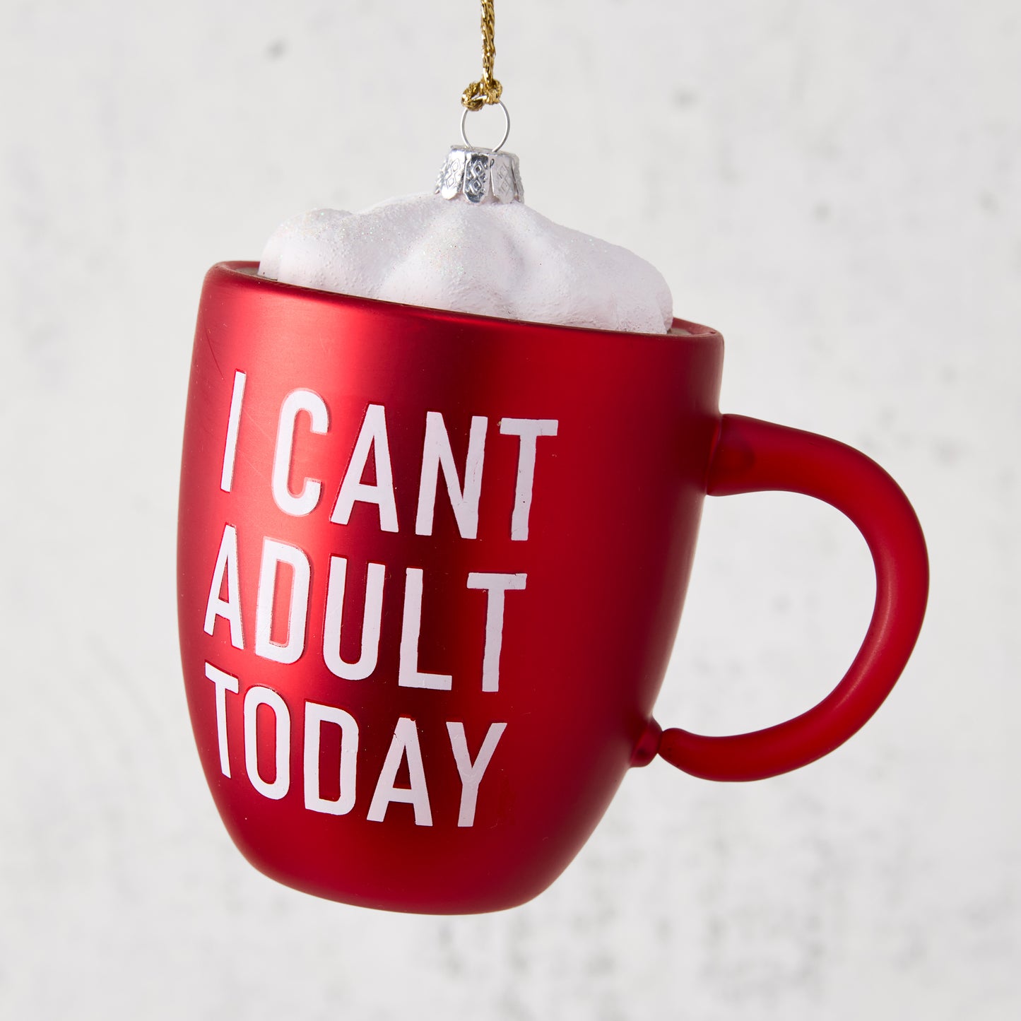 Red mug ornament with "I CAN'T ADULT TODAY" in white, topped with white whipped cream, gold string.