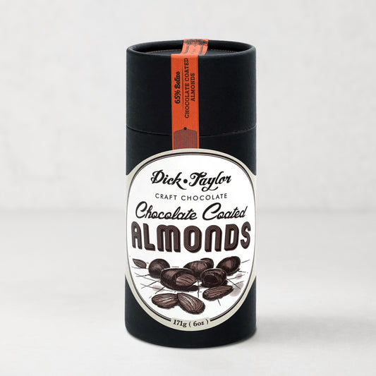 Dick Taylor Chocolate Coated Almonds in a tall, black cylindrical container with a white and black label.