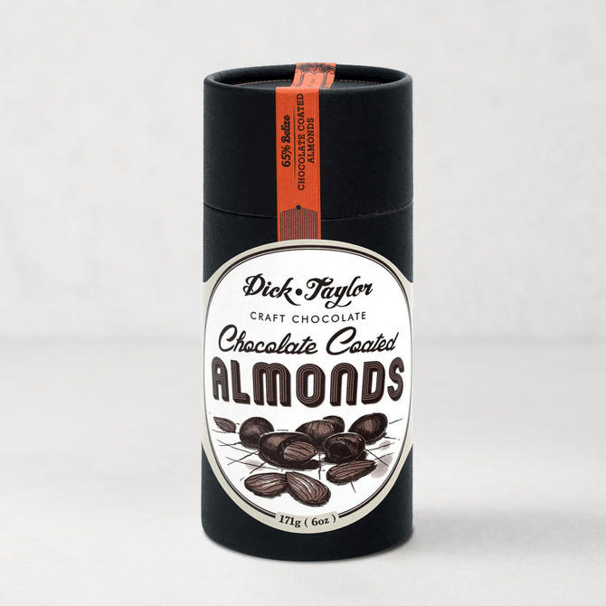 Dick Taylor Chocolate Coated Almonds in a tall, black cylindrical container with a white and black label.