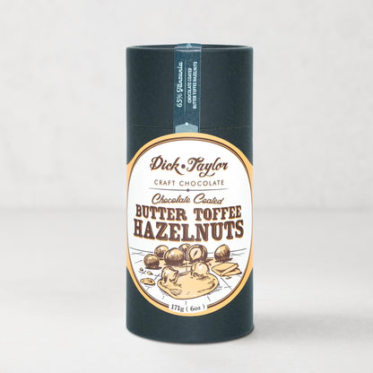 Dick Taylor Chocolate Coated Butter Toffee Hazelnuts in a dark blue cylindrical container with an oval label.
