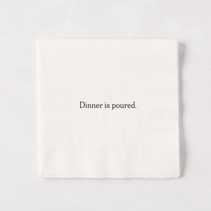 White 5.5" square paper cocktail napkin with "Dinner is poured." in black text.