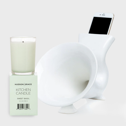 White ceramic kitchen speaker with a smartphone and a Sweet Basil Kitchen Candle in a glass jar.