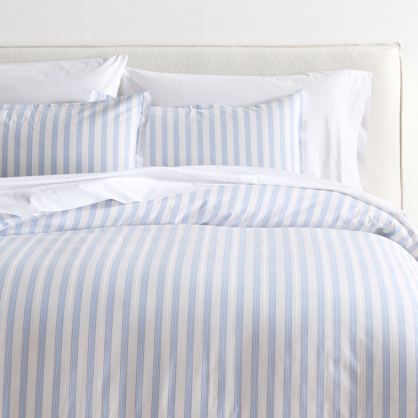 Dobby Blue Stripe Cotton Euro Shams and duvet cover set on a bed.
