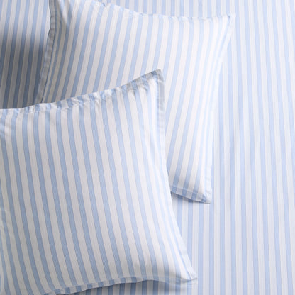 Two Dobby Blue Stripe Cotton Euro Shams with subtle texture, on a matching striped sheet.