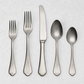 Dolce Vita 5-piece flatware set in matte stainless steel with vintage Neo-Baroque design on a white background.
