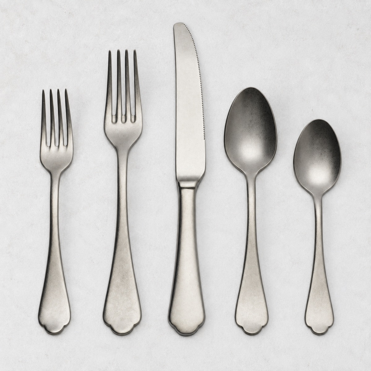 Dolce Vita 5-piece flatware set in matte stainless steel with vintage Neo-Baroque design on a white background.