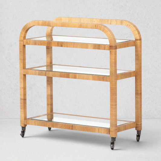 Dory Rattan Bar Cart: Honey-finished rattan bar cart with three glass tiers and wheels.