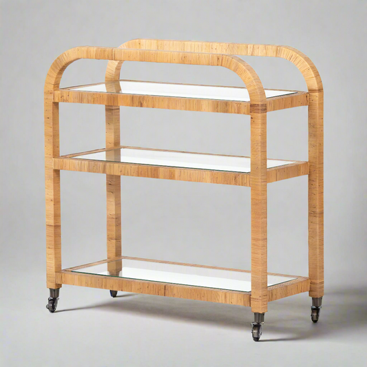Dory Rattan Bar Cart: Honey-finished rattan bar cart with three glass tiers and wheels.