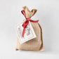 Dr. Pete's Cranberry Herb Focaccia bread mix in a tan burlap sack tied with a red ribbon and a white product label.