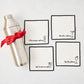 Silver cocktail shaker with red ribbon and four white embroidered coasters featuring cocktail designs.