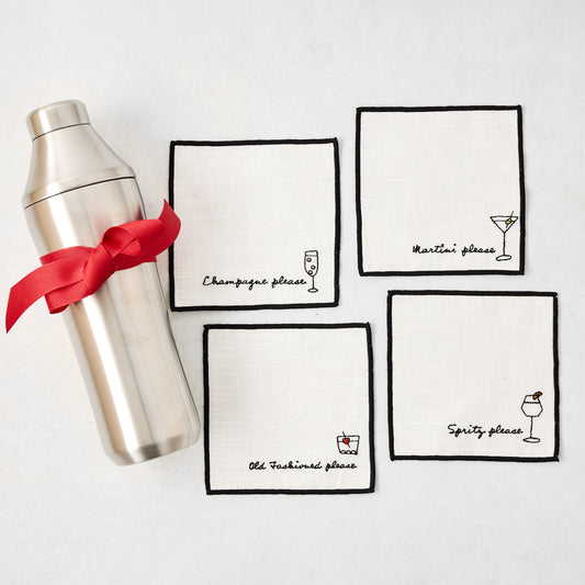 Silver cocktail shaker with red ribbon and four white embroidered coasters featuring cocktail designs.