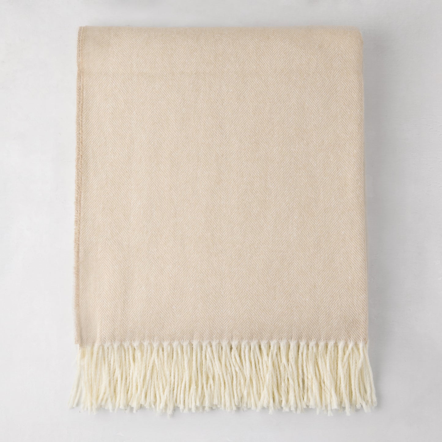 Dune Italian Herringbone Throw Blanket, cashmere-soft cotton-acrylic, with decorative fringe.