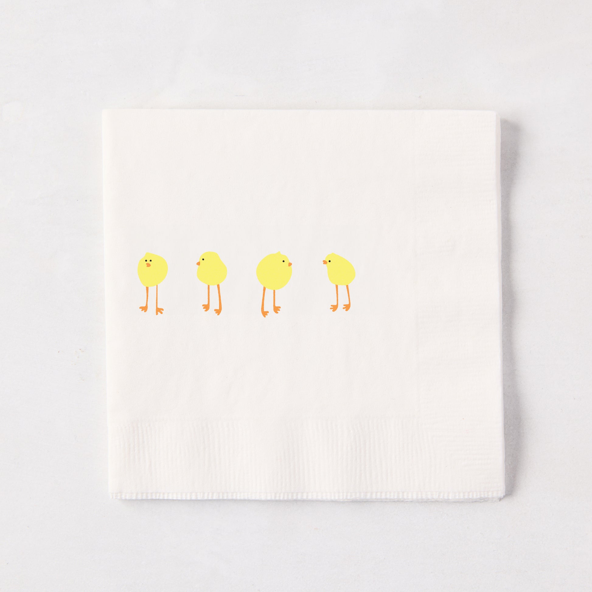 White 3-ply paper cocktail napkin with four yellow Easter chicks, 5.5" square.