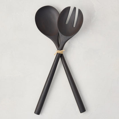 Ebony teak wood long-handled 2-piece serving set, spoon and fork, tied with twine on a white background.