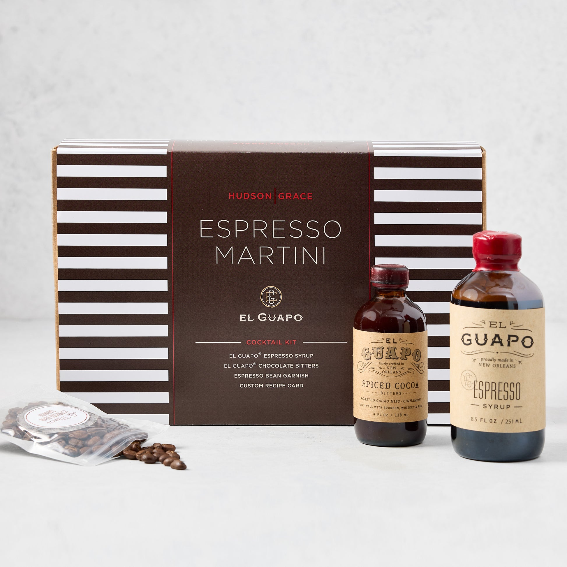 El Guapo Espresso Martini Cocktail Kit with striped box, espresso syrup, spiced cocoa, and coffee beans.