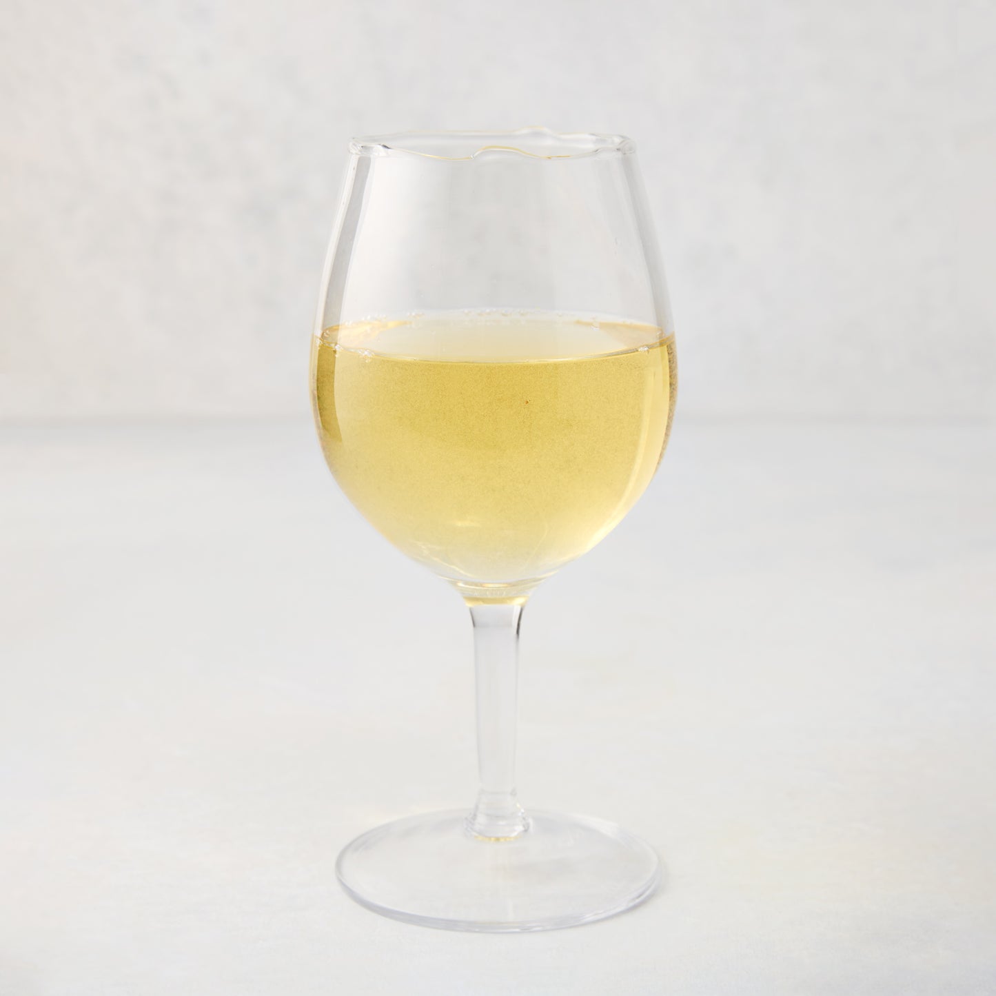 Elijah Small Scissor-Cut Wine Glass, 12 oz., clear air-blown glass with white wine.