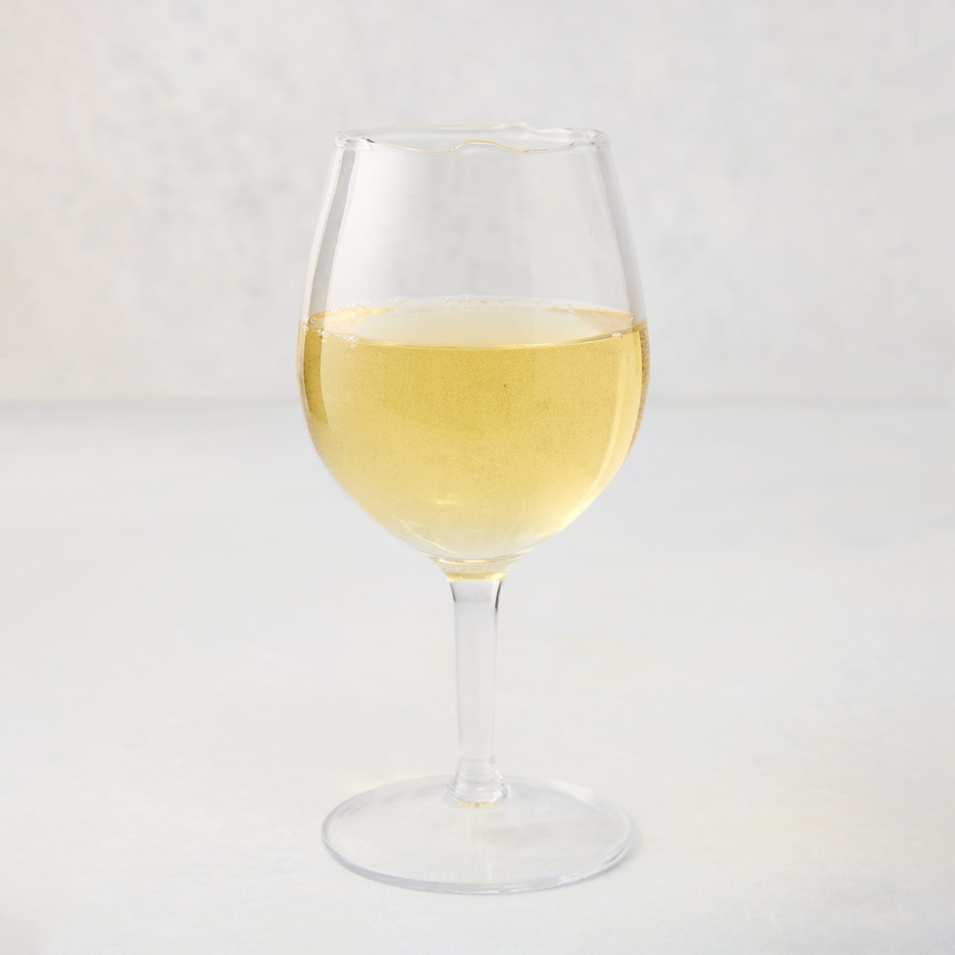 Elijah Small Scissor-Cut Wine Glass, 12 oz., clear air-blown glass with white wine.