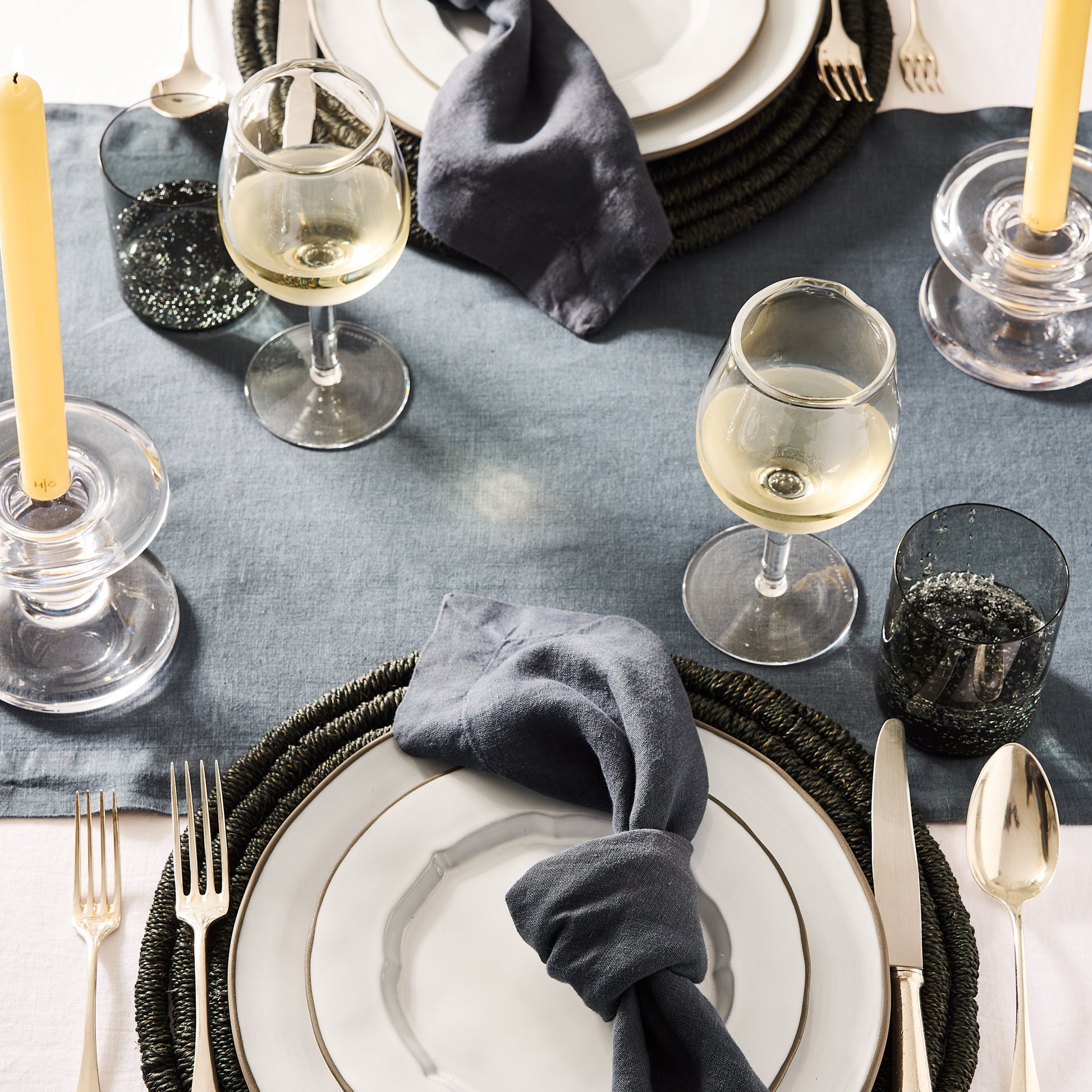 Elijah Small Scissor-Cut Wine Glass, 12 oz., made from thick, air-blown glass, on a set table.