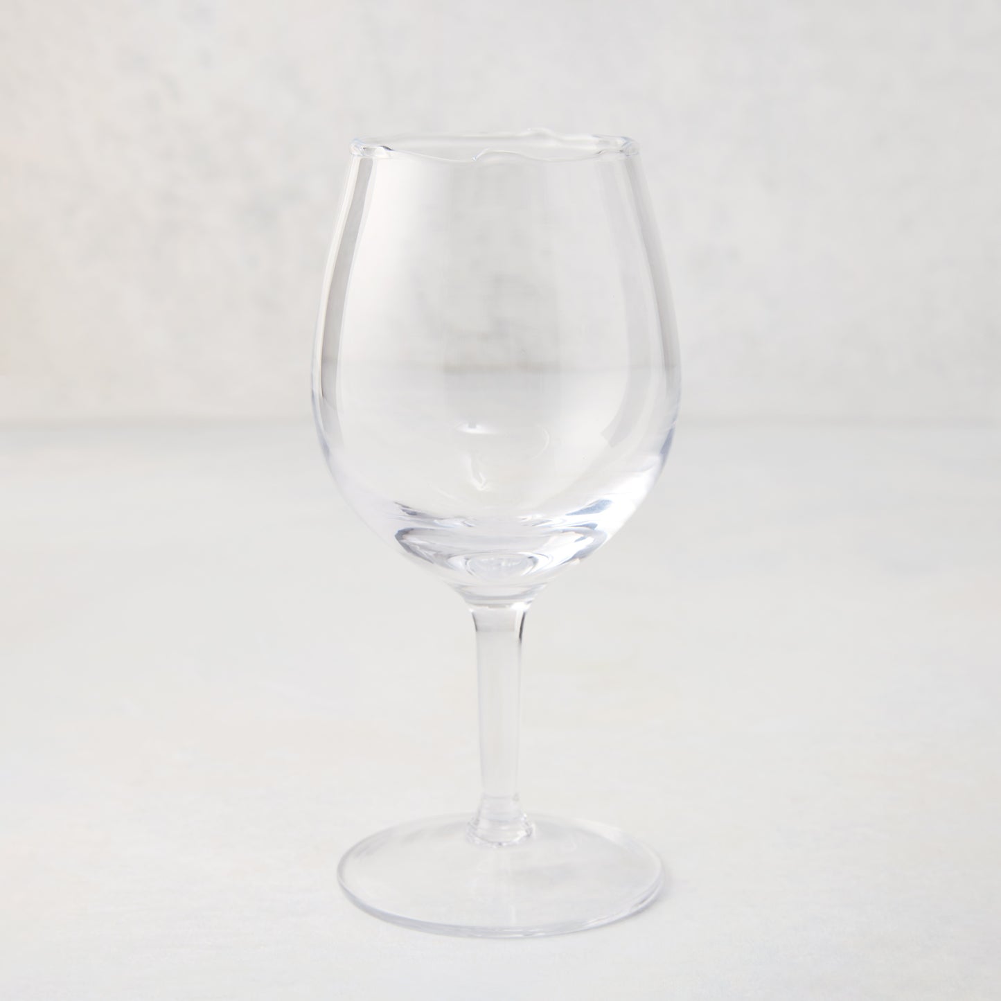Elijah Small Scissor-Cut 12 oz. clear, thick air-blown glass wine glass with rippled rim.