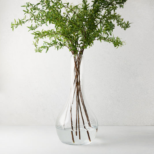 Elise Glass Vase, 19.5"H, mouth-blown clear glass, traditional shape, with green leafy stems.