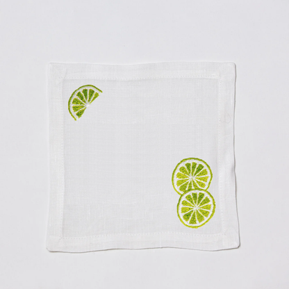 White linen cocktail napkin coaster with embroidered lime slices.