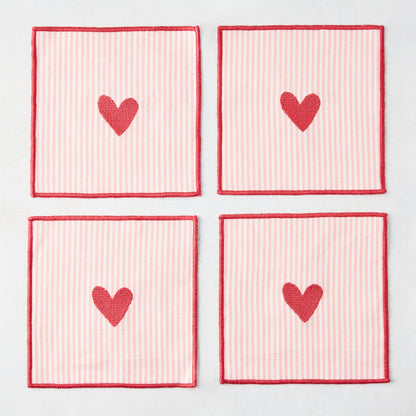 Set of 4 square cotton coasters with pale pink and white stripes, red embroidered hearts, and red edges.