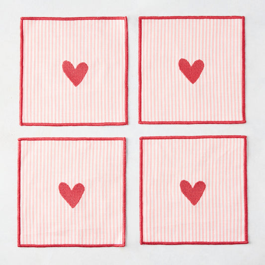Set of 4 square cotton coasters with pale pink and white stripes, red embroidered hearts, and red edges.