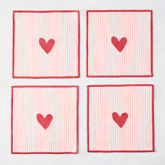 Set of 4 square cotton coasters with pale pink and white stripes, red embroidered hearts, and red edges.