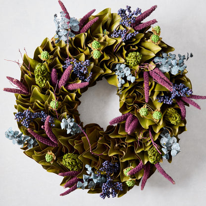 Enchanted Forest Wreath with green magnolia leaves, blue juniper berries, plum millet, and green magnolia pods.