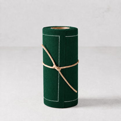 Roll of 50 English green cotton cocktail napkins with white stitched borders, tied with a natural twine string.