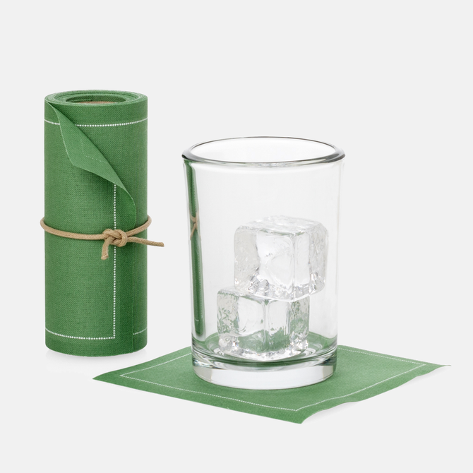 Roll of 50 eucalyptus green cotton cocktail napkins with white stitching, next to a glass with ice on a single napkin.