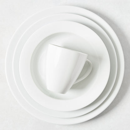 Stacked white porcelain dinnerware: dinner plate, salad plate, and mug from the Everyday collection.