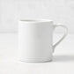 White porcelain mug with a curved handle from the Hudson Grace Everyday collection, 4.3 inches tall.