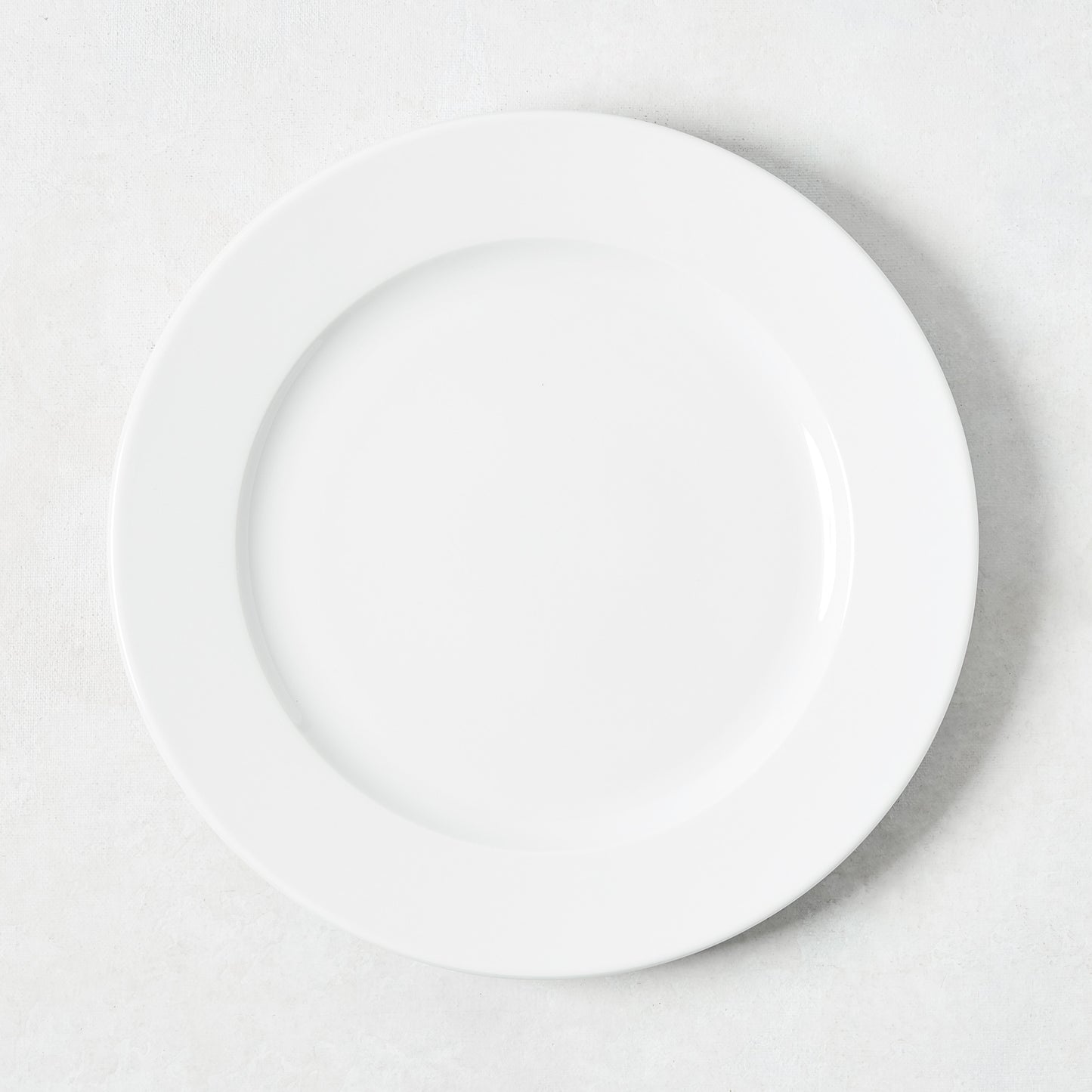 White porcelain salad plate with a classic rim from the Everyday Collection.