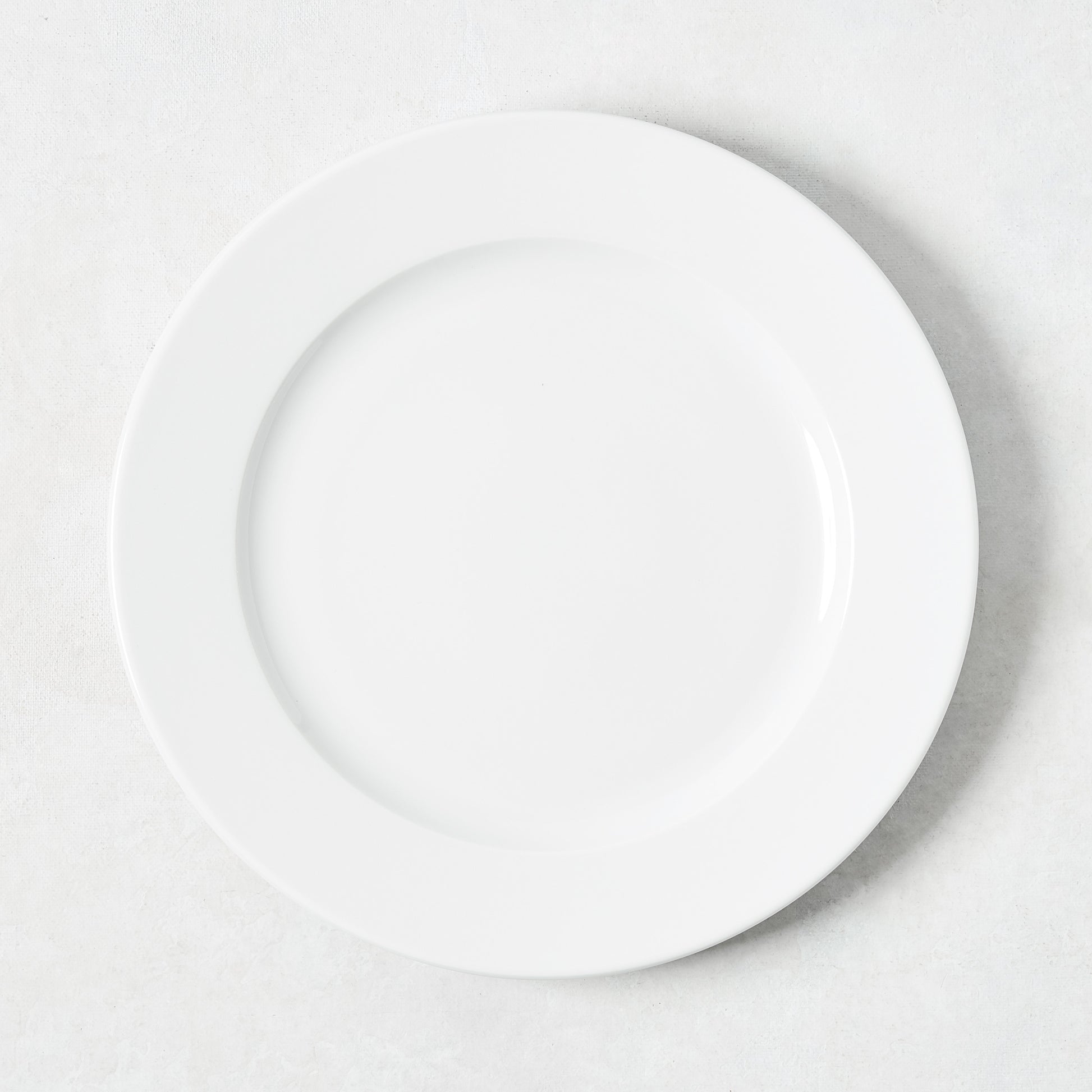 White porcelain salad plate with a classic rim from the Everyday Collection.