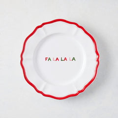 7-inch white ceramic appetizer plate with a scalloped red rim and hand-painted multicolored Fa La La La text.