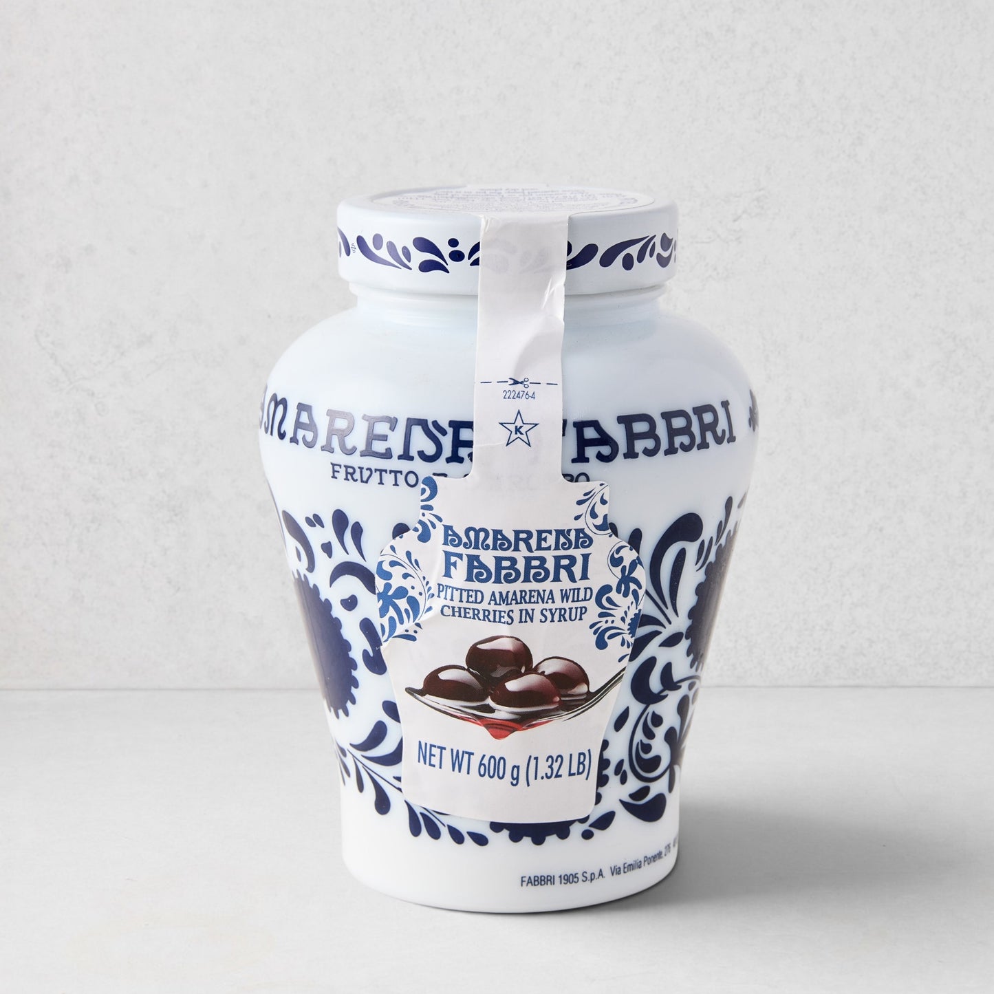White ceramic Fabbri Amarena cherries jar with blue floral design and product label.