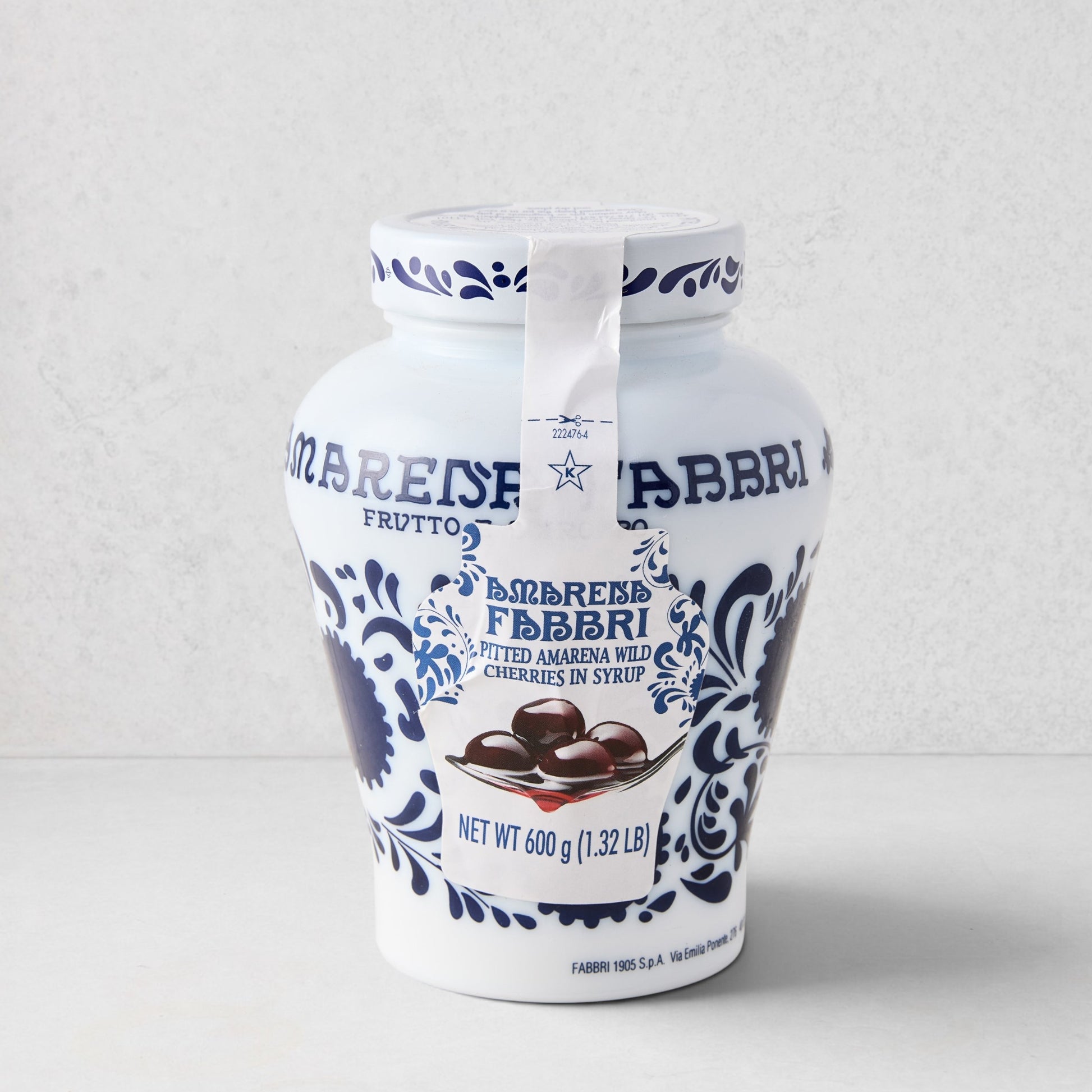 White ceramic Fabbri Amarena cherries jar with blue floral design and product label.