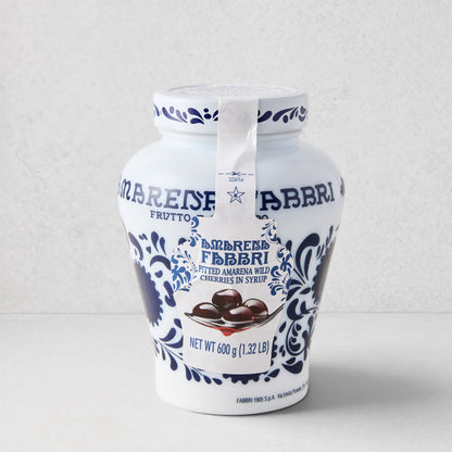 White ceramic Fabbri Amarena cherries jar with blue floral design and product label.